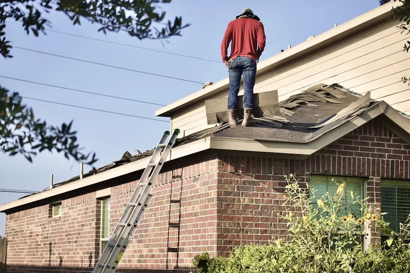 Professional roofer working on a residential roof in Grand